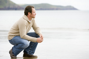 Man crouching on beach help low self-esteem